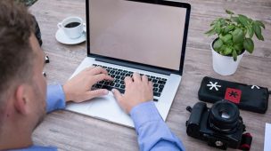 Homem na frente de um laptop. Trabalhando em casa com computador. Como gerar renda extra através do computador e celular