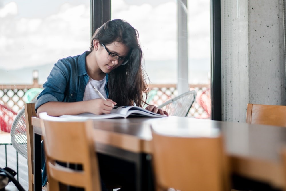 Empreender online, estudante sentada a mesa estudando para empreender online