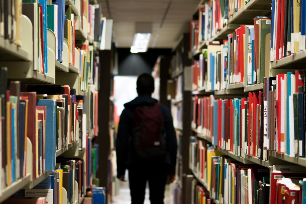 Pessoa no corredor da biblioteca seja protagonista na faculdade