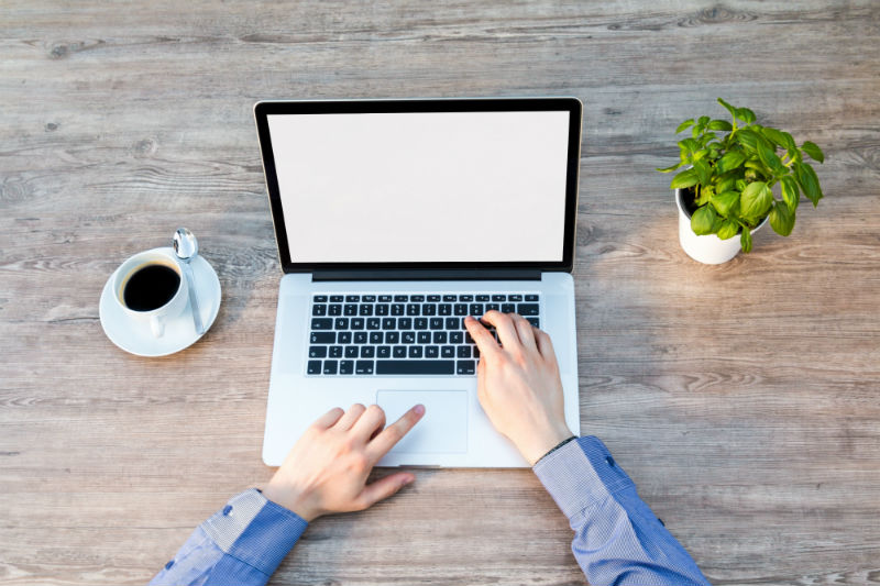 Estudante usando notebook para trabalhar em casa como produtor digital