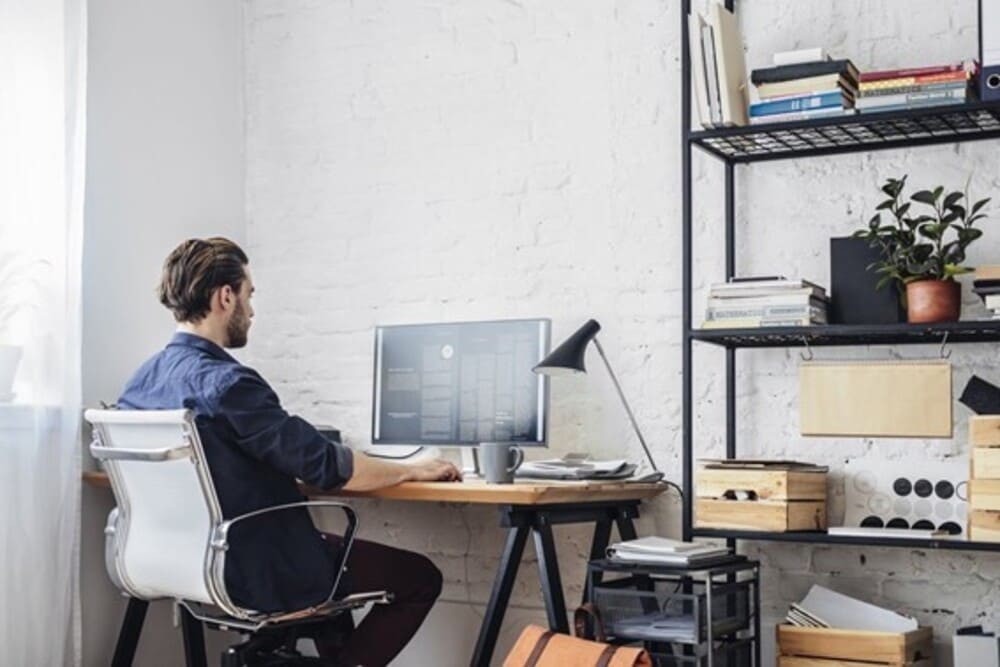 Homem em frente ao computador trabalhando em home office com marketing de afiliados
