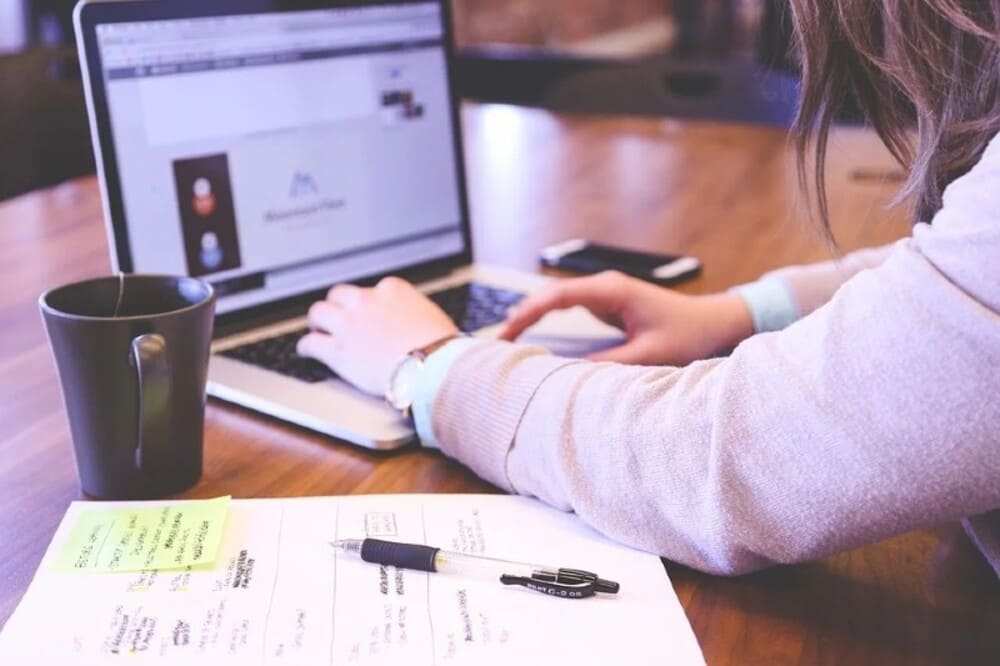 Universitário usando computador em casa vendendo produtos digitais