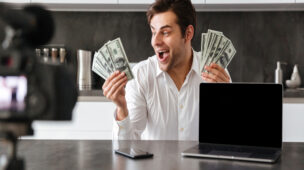 Homem feliz com dinheiro nas mãos demonstrando Como Ganhar Dinheiro com Marketing Digital Afiliado Eduzz